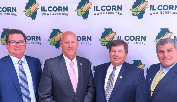 A group of men standing in front of a banner that says ilcorn