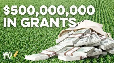 A bag of money is sitting on top of a pile of money in a field.