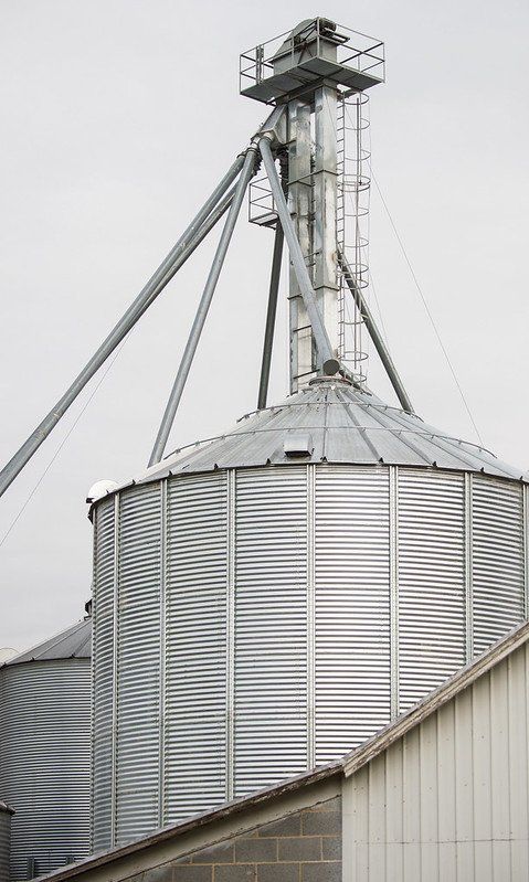 A large metal silo is sitting on top of a building.