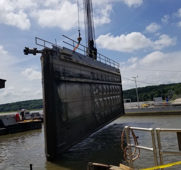 A boat is being lifted into the water by a crane