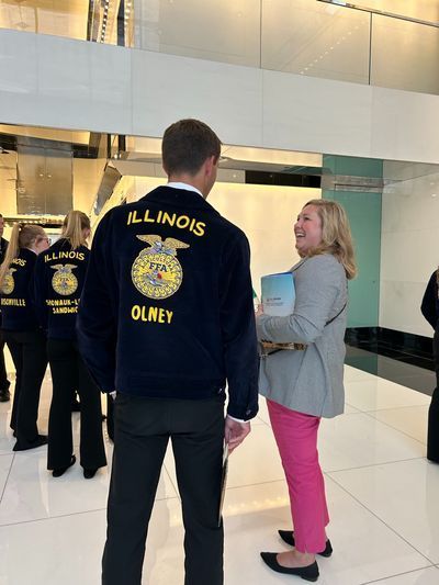 A man in an illinois olney jacket stands next to a woman
