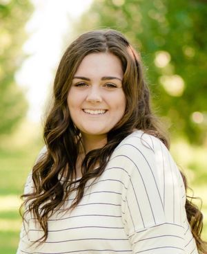 A woman in a striped shirt is smiling for the camera.