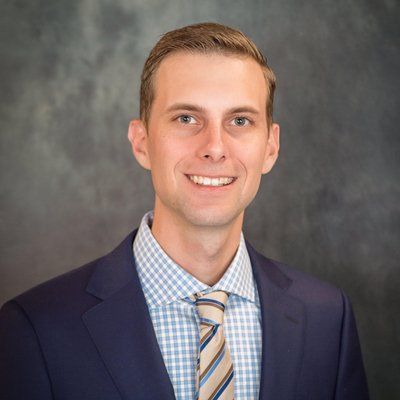 A man in a suit and tie is smiling for the camera.