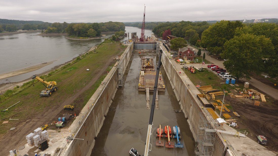 An aerial view of a large body of water with a crane in the middle of it.