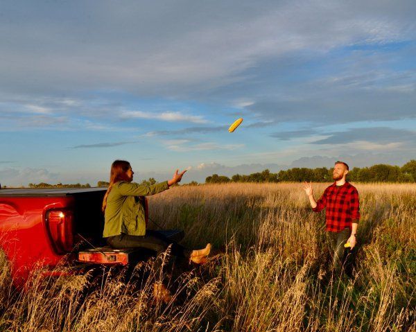 A man and a woman are throwing a frisbee in a field.