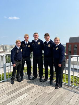 A group of people are posing for a picture on a balcony.