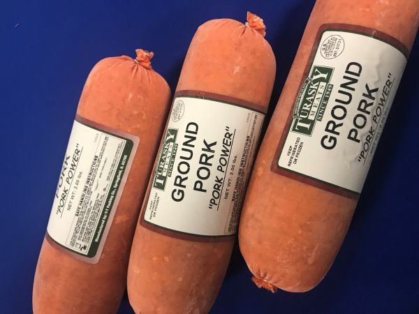 Three rolls of ground pork on a blue surface