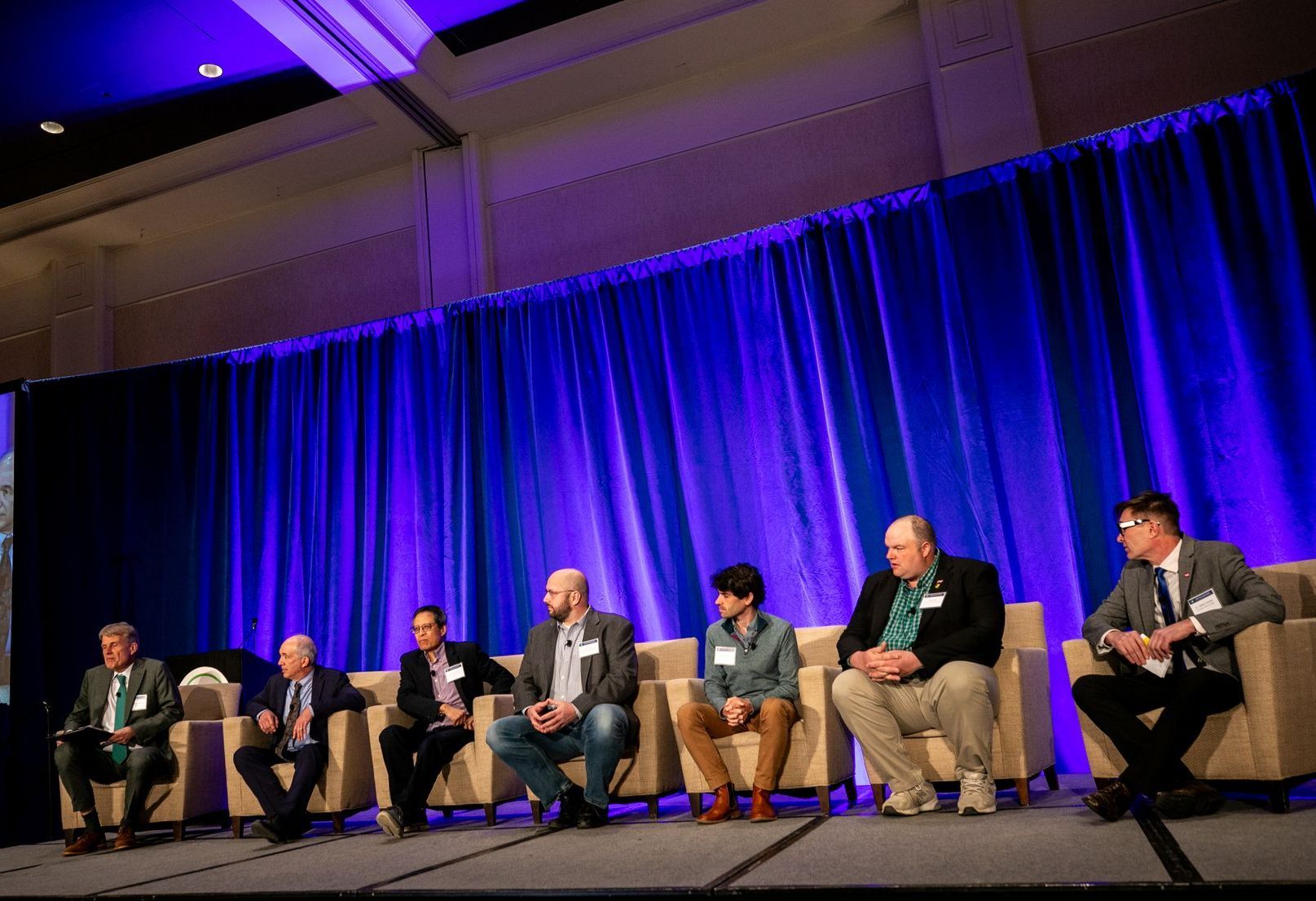 A group of people are sitting in chairs on a stage.