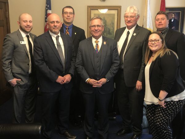 A group of men in suits and ties pose for a picture
