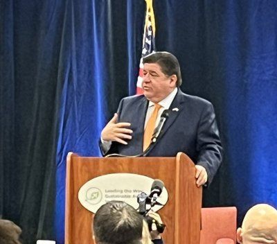 A man in a suit and tie is giving a speech at a podium