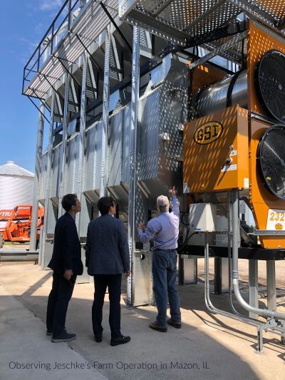 Three men are standing in front of a machine with the number 693 on it