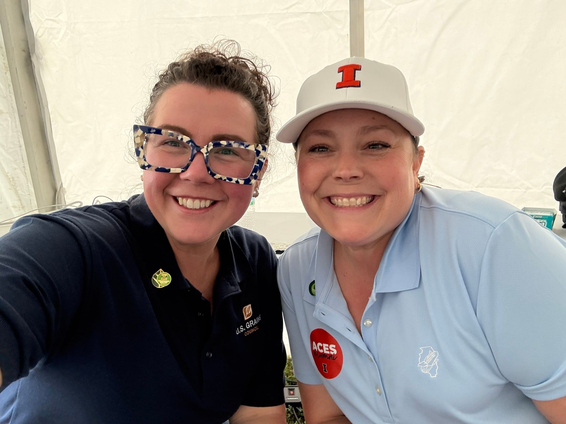 Two women smiling, one wearing a white 