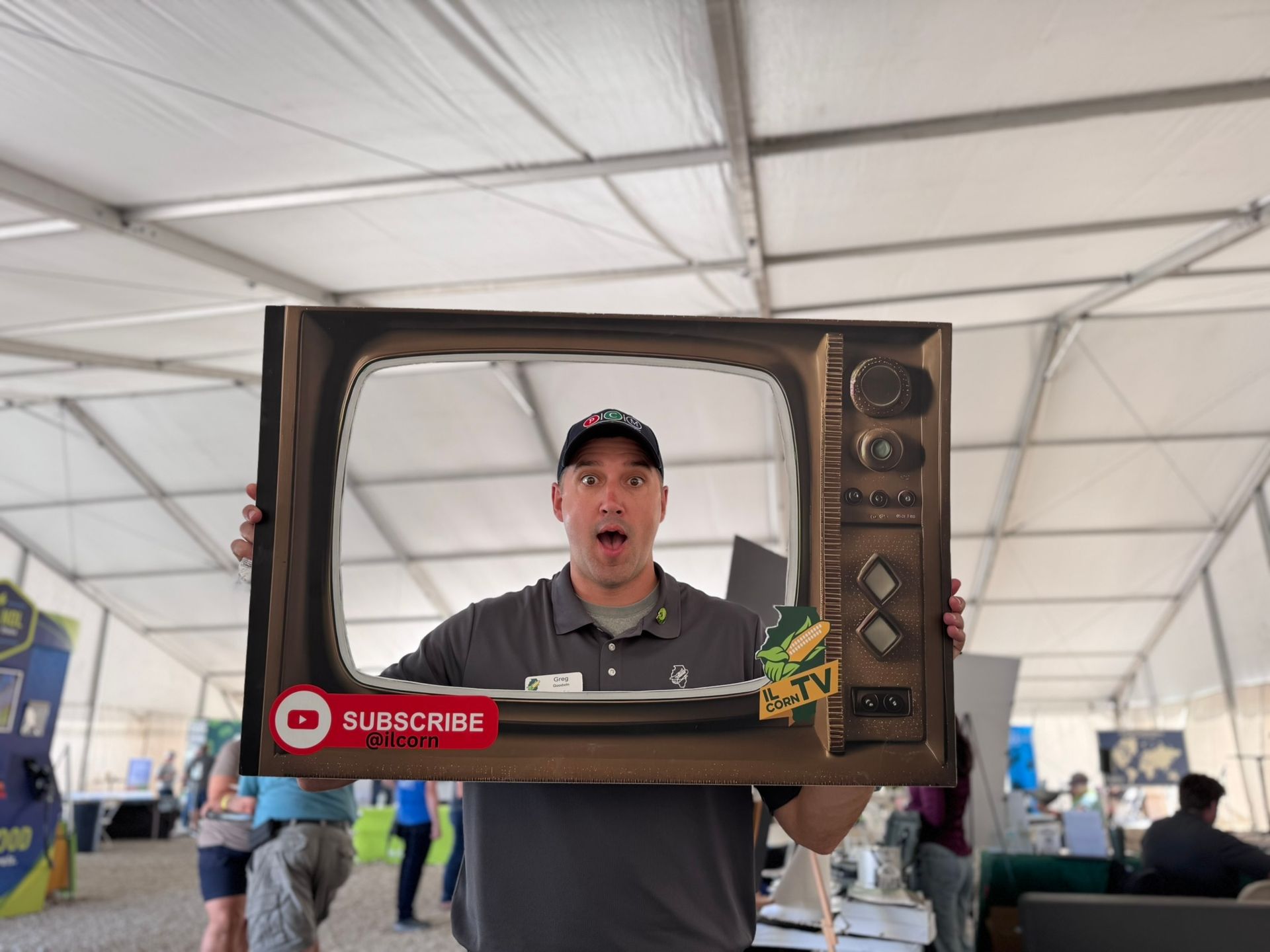 Man holding a painted vintage TV frame, making a surprised face, with a 