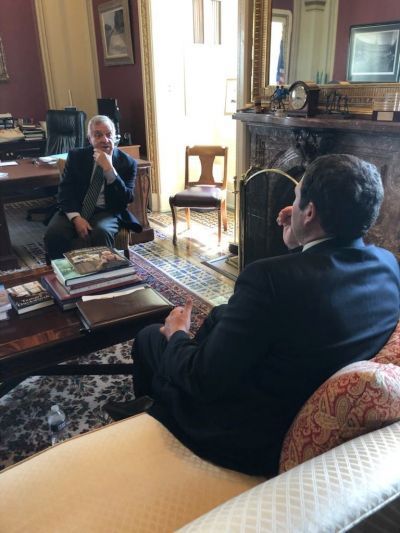 Two men are sitting in a living room talking to each other