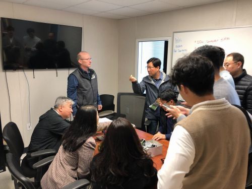 A group of people are sitting around a table in a conference room.