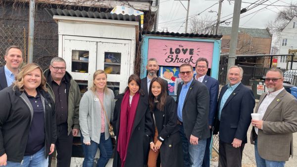 A group of people are posing for a picture in front of a love shack.