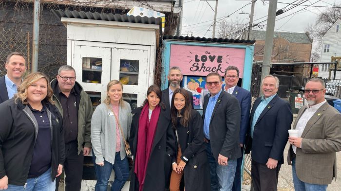 A group of people are posing for a picture in front of a love shack.