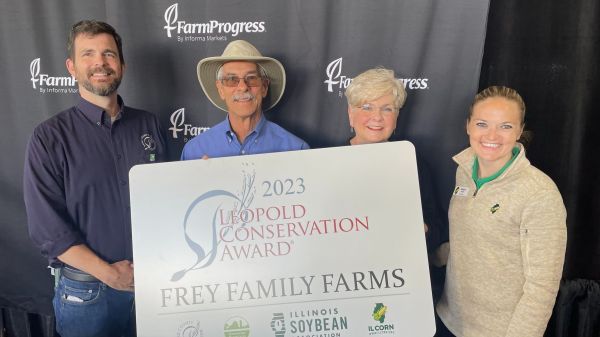 A group of people holding a sign that says frey family farms