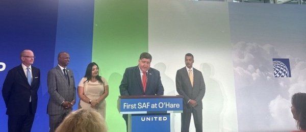 A group of people standing around a podium that says first saf at ohare united
