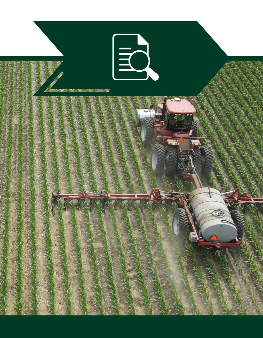 A tractor is spraying a field of plants with a magnifying glass.