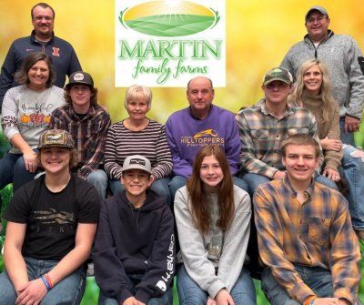 A group of people are posing for a picture in front of a martin family farm sign.