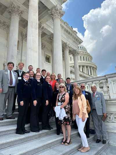 A group of people are posing for a picture on the steps of the capitol building.