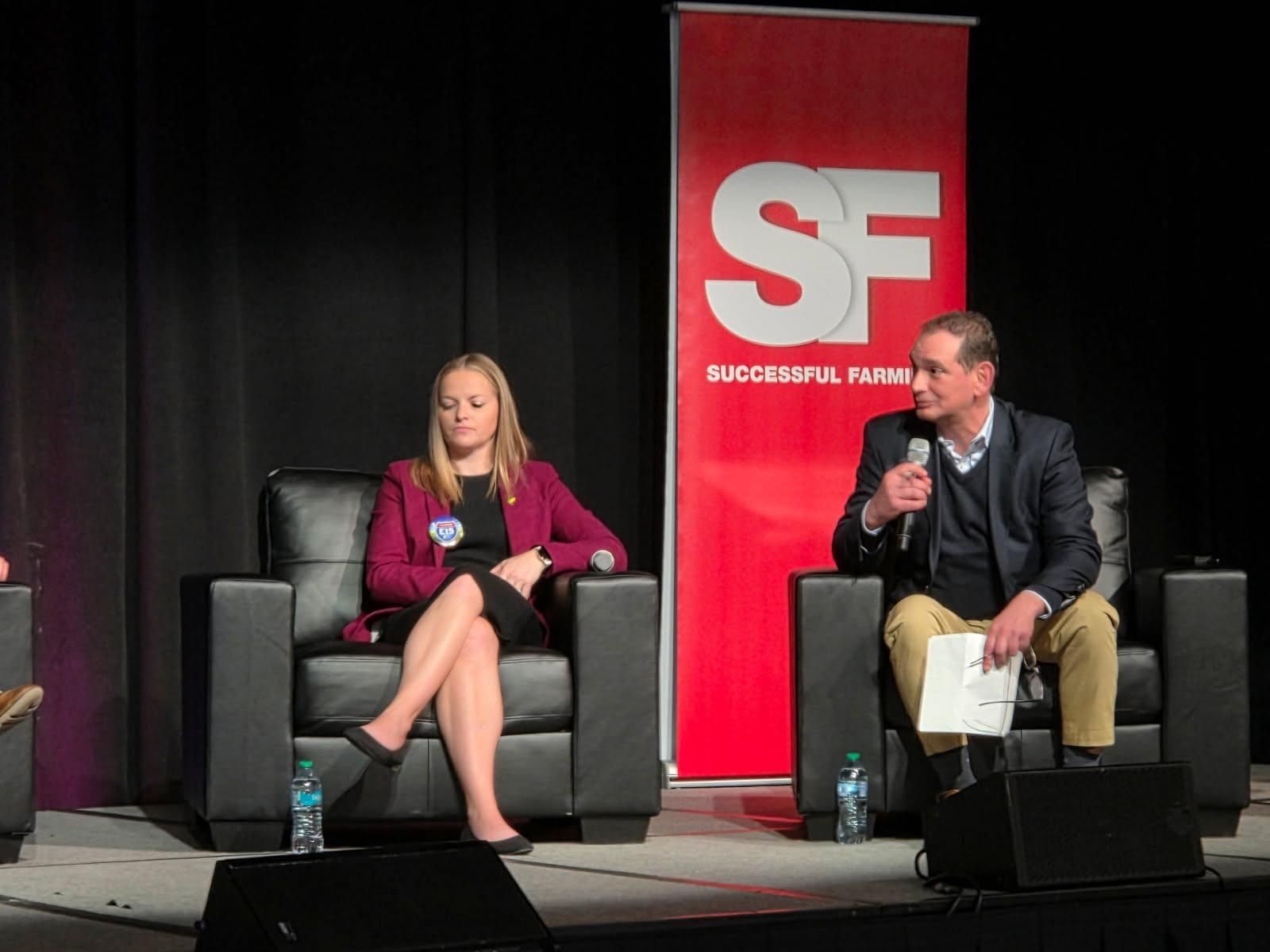 Panelists seated on stage with 