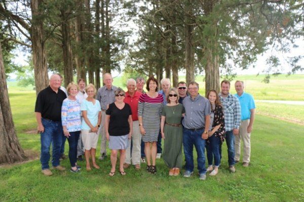 A group of people are posing for a picture in a field.