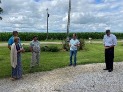 A group of people are standing in a grassy field.