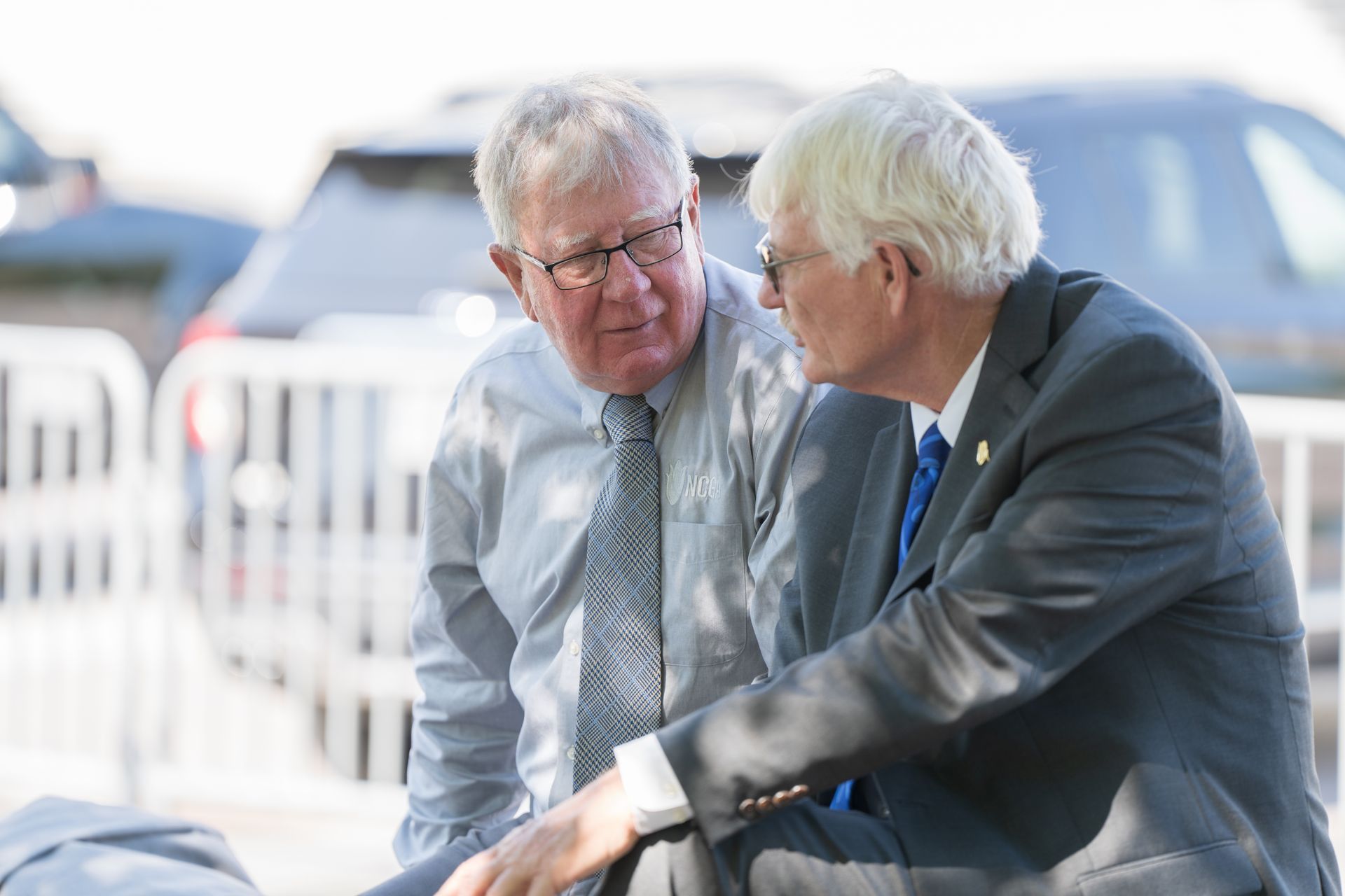 Two men in suits and ties are talking to each other.
