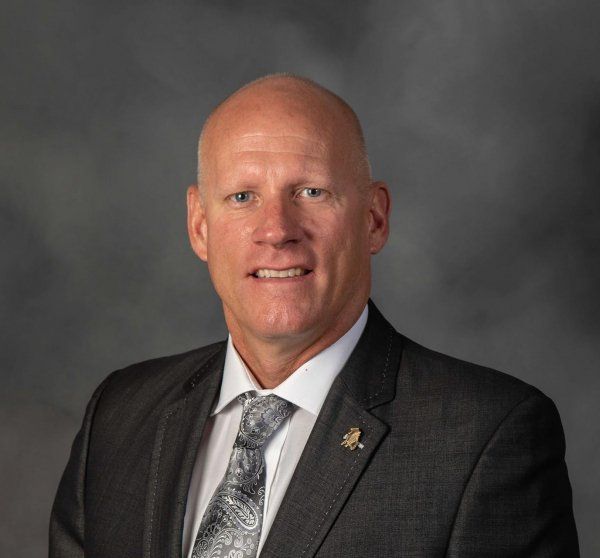A man in a suit and tie is smiling for the camera