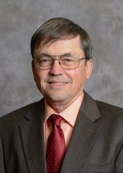 A man in a suit and tie is smiling for the camera