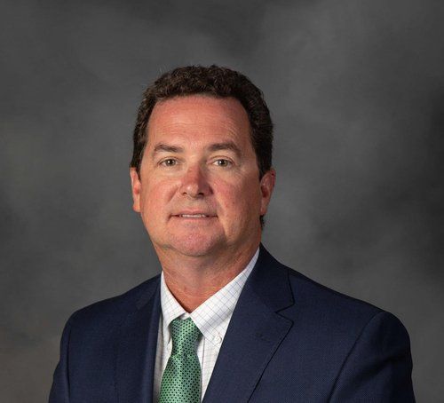 A man in a suit and tie is smiling for the camera.