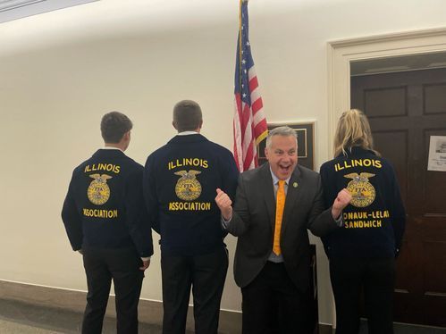A group of people wearing illinois jackets are standing next to each other