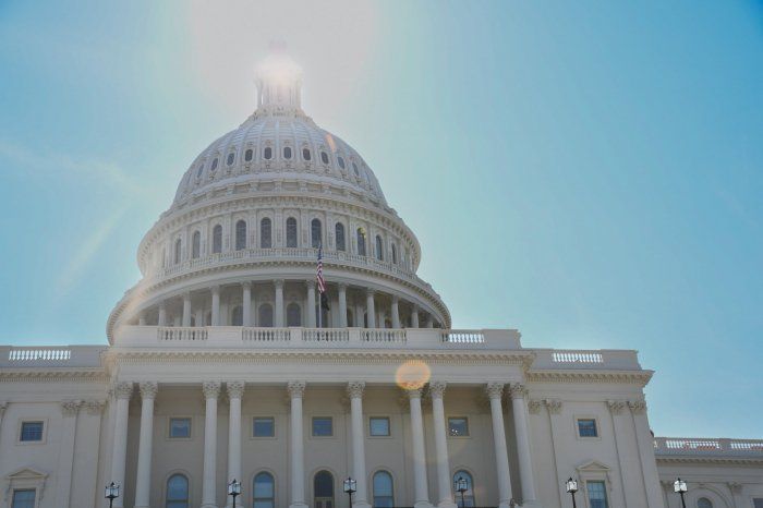 The sun is shining on the dome of the capitol building.