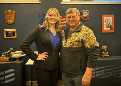 A man and a woman are standing next to each other in a room.