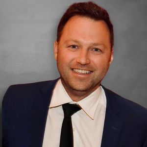 A man in a suit and tie is smiling for the camera.