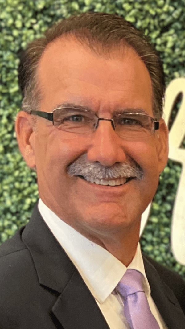 A man in a suit and tie is smiling for the camera.