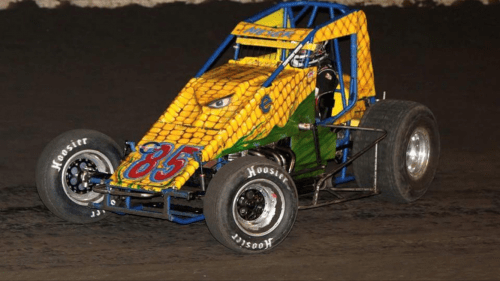 A yellow and blue race car with the number 83 on it