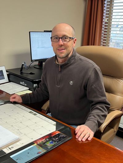 A man is sitting at a desk in front of a computer.