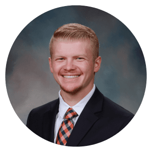 A man in a suit and tie is smiling in a circle