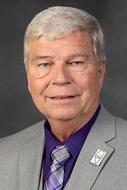 A man in a suit and tie is smiling for the camera.