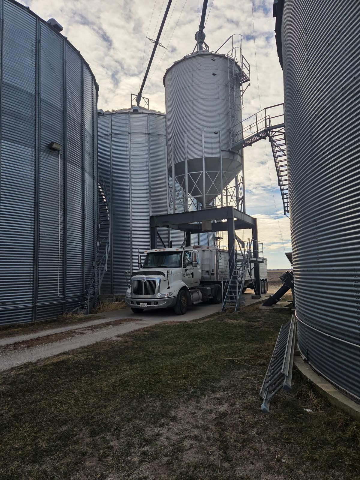 Truck loading grain at silos on a farm.