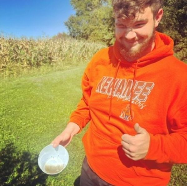 A man wearing an orange hoodie that says kentucky giving a thumbs up