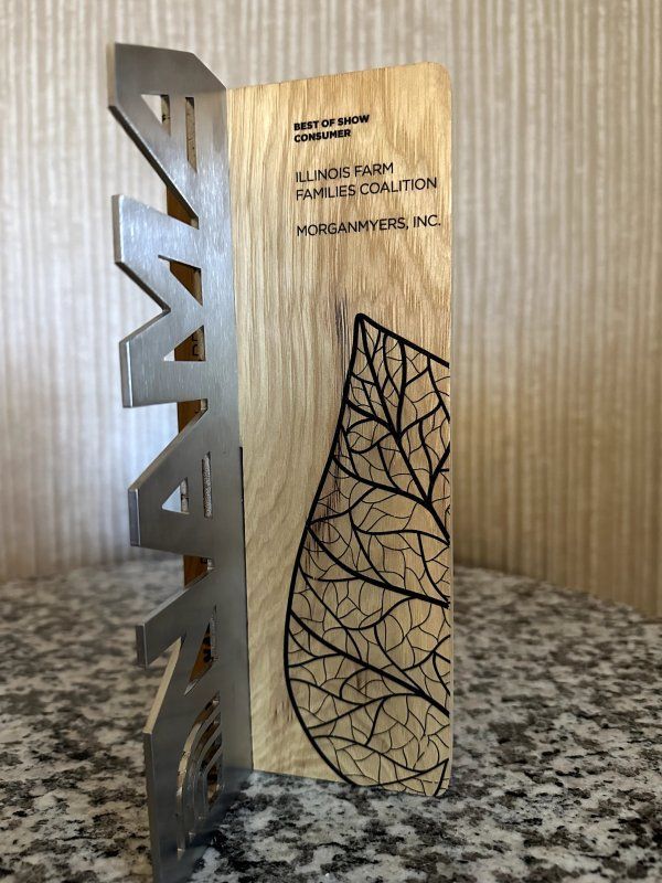 A wooden and metal plaque with a leaf on it
