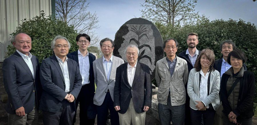 A group of people are posing for a picture in front of a statue.
