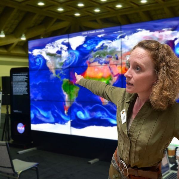 A woman pointing at a map of the world