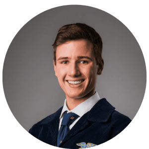 A young man in a suit and tie is smiling for the camera