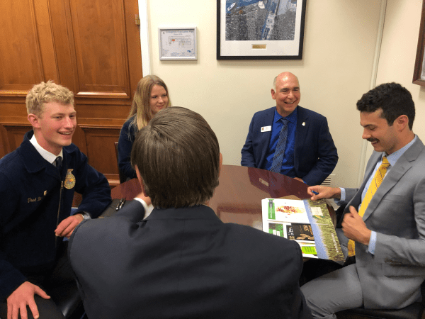 A group of people in suits are sitting around a table