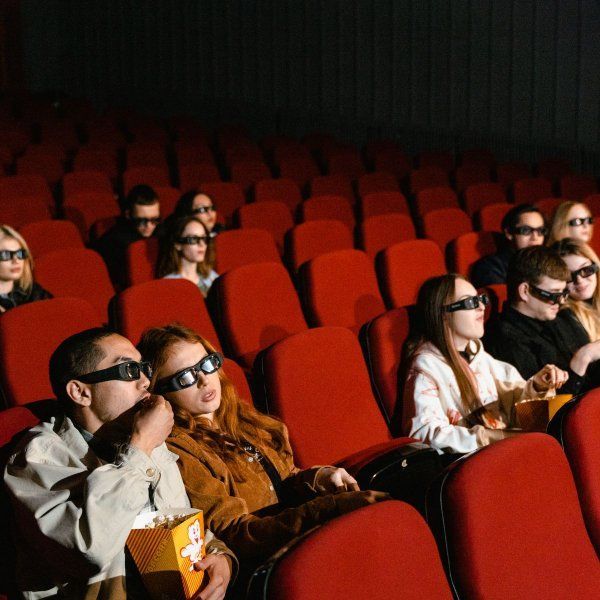 A group of people wearing 3d glasses are watching a movie